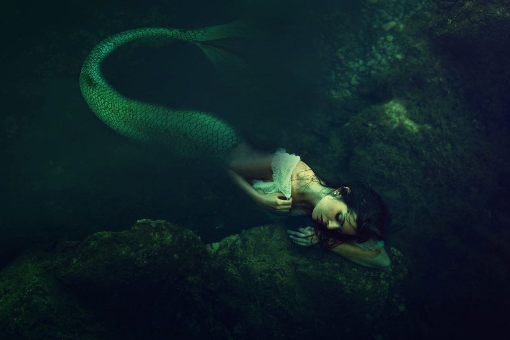 broken beautiful siren lying under water sullen looking
